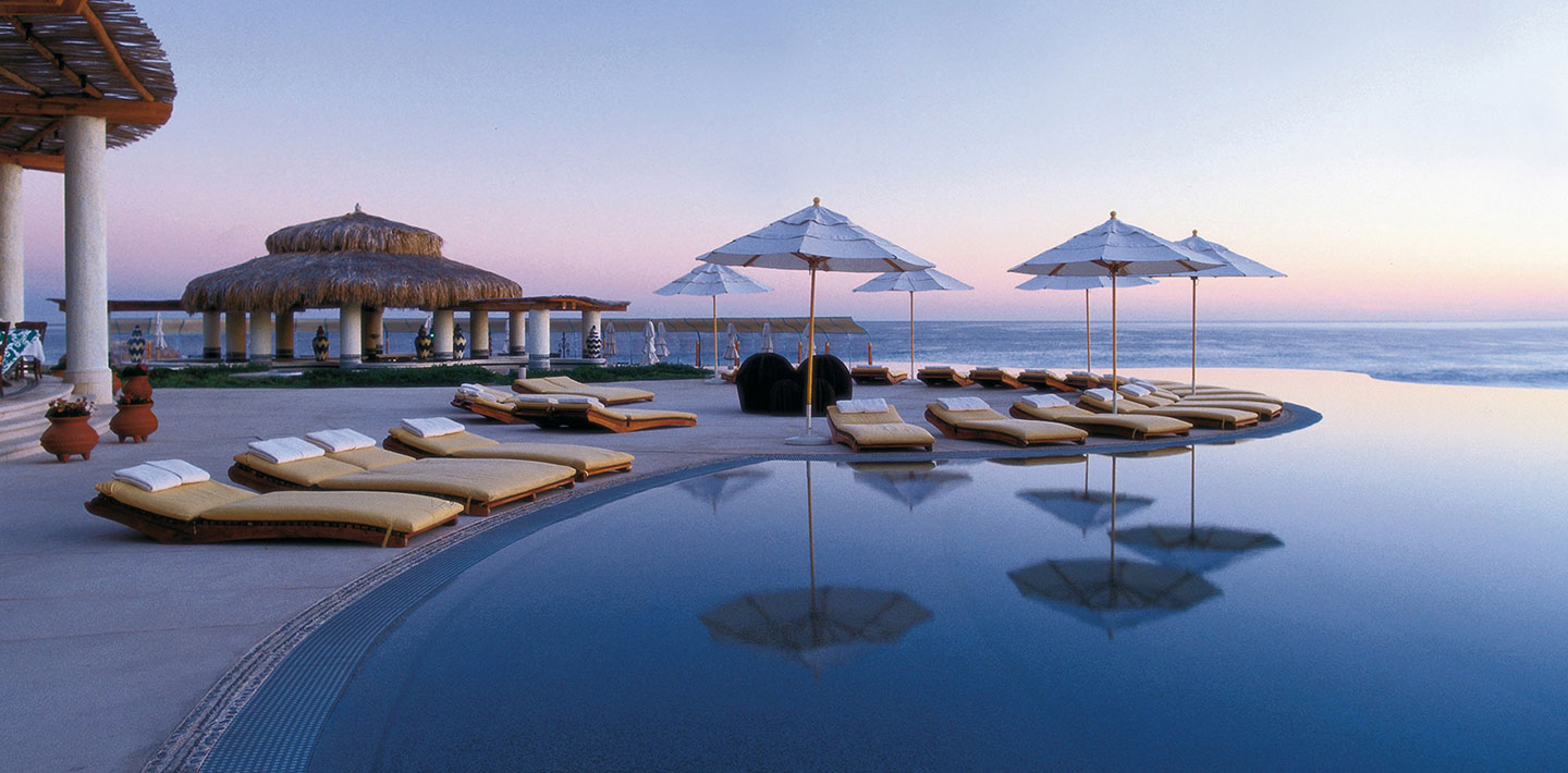 Sonnenbänke mit Schirmen am Strandpool eines Luxus-Hotels